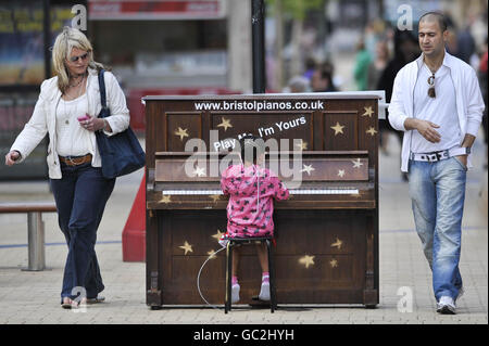 Der 4-jährige Ashanti James aus Fishponds spielt ein einsames Klavier im Zentrum von Broadmead, dem Haupteinkaufsviertel von Bristol, das Teil einer Kunstinstallation mit dem Titel „Play Me“ des Künstlers Luke Jerram aus Bristol ist. Stockfoto