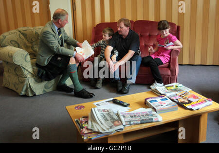 Der Prinz von Wales spricht mit Adam Farquhar und seinem Sohn Adam, 7, und Tochter Emma, 8, Die Opfer der Überschwemmungen im schottischen Moray-Gebiet im Bishopmill House waren, einem ehemaligen Pflegeheimen in Elgin, das zur Behausung von Menschen genutzt wird, die bei den Überschwemmungen ihr Zuhause verloren haben. Stockfoto