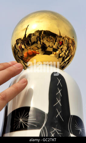 A Woman passt eine der riesigen Schachfiguren an, die The Tournament bilden, eine Installation des spanischen Künstlers Jaime Hayon auf dem Londoner Trafalgar Square zum Auftakt des London Design Festivals. Stockfoto