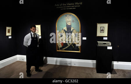 Ein Techniker von Sotheby's in London steht neben einem Porträt des iranischen Monarchen Fath 'Ali Shah Qajar, geschätzt auf 250.000 bis 350,000 beim Verkauf des Auktionators Arts of the Islamic World, der am 7. Oktober stattfinden soll. Stockfoto