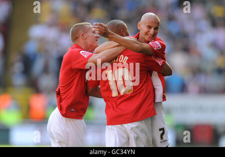 Charlton's Nicky Bailey (links) und Jonjo Shelvey (rechts) von Charlton feiern mit Torschütze Deon Burton während des Coca-Cola League One Matches im Valley, London. Stockfoto