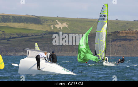 George III blickt von seinem Hang aus hinunter, als das irische Team von Ed Butler und Rory Fitzpatrick während der Skandia Sail for Gold Regatta auf dem Ärmelkanal das kenterte schwedische Boot von Carl Sylvan und Jonas Lindberg in der 49er Klasse anfährt. Stockfoto