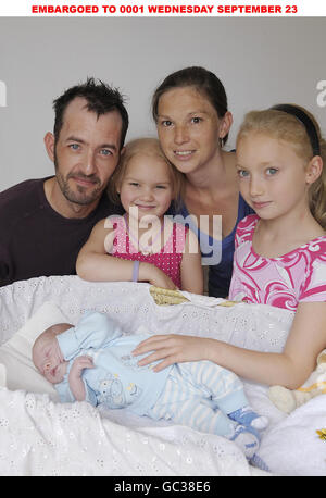 Das erste Baby des Ormond Street Hospital, 20/09/2009. Dave Abbott, 38, Partner Nicola Tyler, 32, und Nicola's Töchter, Kelly Tyler, sechs, links und Chloe Tyler, neun, rechts, von First Avenue, Canvey Island, Essex, mit der neuen Ankunft der Familie von zwanzig Tagen, Zac Abbott, das erste Baby, das im Great Ormond Street Hospital, London, geboren wurde, nachdem Nicola während des Krankenhausaufenthalts zur Wehen ging. Stockfoto