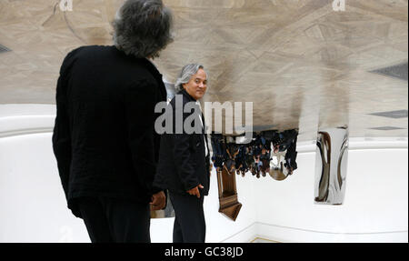 Der Künstler Anish Kapoor steht vor seinem Werk Vertigo, 2008, einer Installation aus reflektierendem Edelstahl, während einer Pressevorschau einer großen Einzelausstellung seiner Arbeit an der Royal Academy of Arts im Zentrum von London. Stockfoto