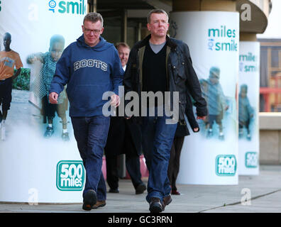 Die Verkünder Craig und Charlie Reid (ohne Brille) helfen, Geld zu sammeln, indem sie eine Meile in Edinburgh laufen, was bis zu 500 Meilen für die Miles for Smiles-Veranstaltung summieren wird. Stockfoto