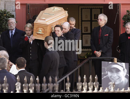 Der Sarg wird nach der Beerdigung von Stephen Gately von Mitgliedern von Boyzone, darunter Ronan Keating (vorne links), Mikey Graham (vorne rechts), Shane Lynch (hinten rechts) St. Laurence O'Toole Church in Dublin durchgeführt. Stockfoto