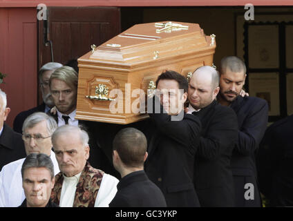 Der Sarg wird nach der Beerdigung von Stephen Gately von Mitgliedern von Boyzone, darunter Ronan Keating (vorne links), Mikey Graham (vorne rechts), Shane Lynch (hinten rechts) St. Laurence O'Toole Church in Dublin durchgeführt. Stockfoto