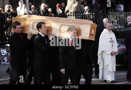 Der Sarg wird nach der Beerdigung von Stephen Gately von Mitgliedern von Boyzone, darunter Ronan Keating (rechts) und Keith Duffy (links) in der St. Laurence O'Toole Church in Dublin, durchgeführt. Stockfoto