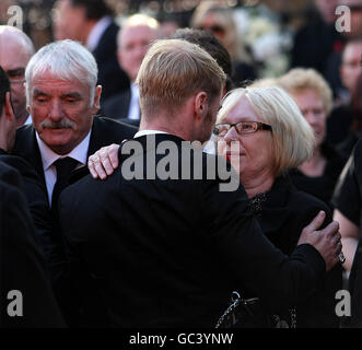 Margaret Gately wird von Ronan Keating vor der St Laurence O'Toole Church in Dublin, wo Stephen Gately's Beerdigung stattgefunden hat, getröstet. Stockfoto