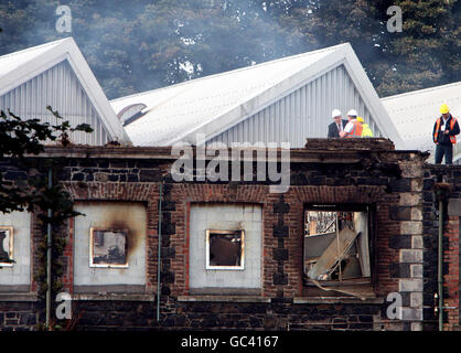 Beamte untersuchen das eingestürzte Dach der Gallaher-Fabrik in Ballymena nach einem Brand über Nacht. Stockfoto