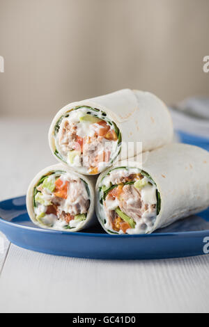 Thunfisch-Wraps mit Avocado-Tomaten-Mayonnaise auf blaue Platte Stockfoto