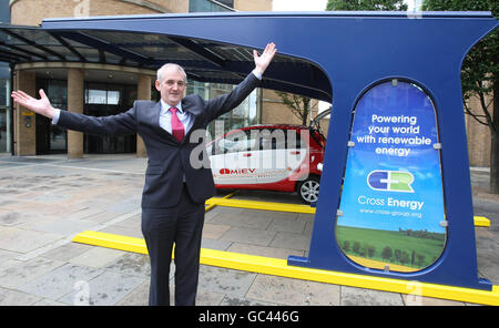 Joe Conway mit seinem Solar-Carport-Ladegerät in Belfast. Der deutliche Mangel an Sonnenschein in Belfast hinderte den Besitzer von Nordirlands erstem solarbetriebenen Autoladegerät heute nicht daran, das Gerät anzuschließen. Stockfoto