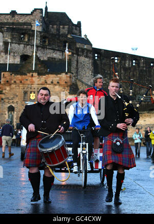 TV-Moderator Ben Fogle und der olympische Goldmedaillengewinnerer James Cracknell werden von der Band Celtic Spirit verpeitscht, bevor sie von Edinburgh Castle zu einer karitativen Rikscha-Fahrt aufbricht. Die 450-Meilen-Challenge „Ride for Britain“ wird Geld für die SSAFA-Streitkräfte sammeln, die Soldaten und Frauen unterstützen. Stockfoto