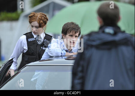 Schauspieler Matt Smith, der elfte Doktor, der mit seiner Assistentin Karen Gillan als Polizist gekleidet war, während der Dreharbeiten in der Nähe der Kathedrale in Llandaff, Cardiff, Wales, wo die neueste Serie von Doctor Who gedreht wird. Stockfoto