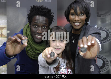 Andy Akinwolere, der Moderator von Blue Peter, Florence Jackson aus Bristol und Denise Lewis halten eine 50 Pence-Münze hoch, die das Design von Florenz zeigt, das London 2012 feiert. Florenz ist das erste Kind, das mit der Royal Mint an der Gestaltung einer britischen Münze arbeitet, nachdem es an einem CBBC Blue Peter Wettbewerb teilgenommen hat. Stockfoto