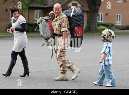 Stabsfeldwebel Kevin Vaughan wird von seiner Frau Christie und seinem Sohn Owen begrüßt, als 75 Royal Engineer und Royal Logistic Corps nach sechs Monaten in Afghanistan Bombenentsorgungs- und Suchspezialisten nach Carver Barracks, Wimbish, Essex zurückkehren. Stockfoto