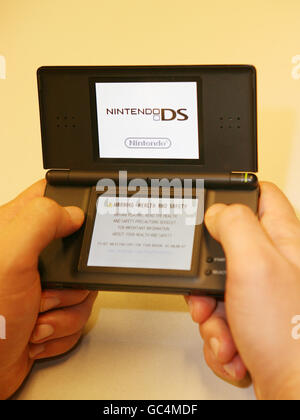 Computerspiel. Ein Mann spielt ein Spiel auf einer Nintendo DS Konsole. Stockfoto