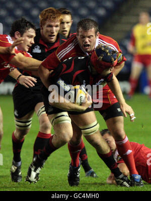 Rugby Union - Magners League - Edinburgh / Münster - Murrayfield. Scott Newlands (vorne) aus Edinburgh hält die Munster-Tackles während des Spiels der Magners League in Murrayfield, Edinburgh, zurück. Stockfoto