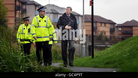 Justizminister Kenny MacAskill (rechts) geht mit dem Hauptkommissar Paul Bullen während eines Besuchs in Wester Hailes in Edinburgh nach der Veröffentlichung der Scottish Crime & Justice Survey 2008/2009. Stockfoto