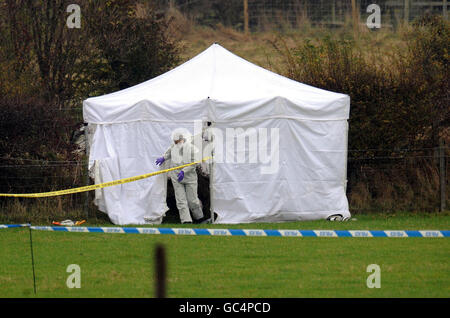 HINWEIS: DER KÖRPER IM ZELT IST SICHTBAR. Ein forensischer Offizier verlässt ein Zelt mit dem Körper eines Teenagers in einem Feld in der Nähe von Sedgefield, County Durham. Stockfoto