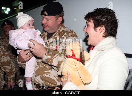 Sergeant Darren Wright von den Lichtdragonen wird von seiner Frau Jo und seinem Baby Olivia, 5 Monate, in Robertson Barracks, Swanton Morley Norfolk, begrüßt, als Soldaten der Lichtdragonen von einer sechsmonatigen Tour durch den Süden Afghanistans nach Hause zurückkehren. Stockfoto