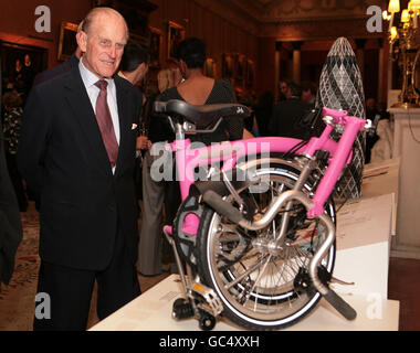Der Duke of Edinburgh bewundert den Gewinner des Prince Philip Designers' Prize, ein pinkes Brompton Klapprad, bei einem Empfang im Buckingham Palace, London. Stockfoto