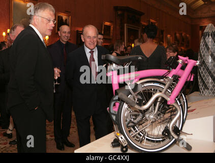 Der Duke of Edinburgh (Mitte) bewundert den Gewinner des Prince Philip Designers' Prize, ein pinkfarbenes Brompton Klapprad, bei einem Empfang im Buckingham Palace, London. Stockfoto