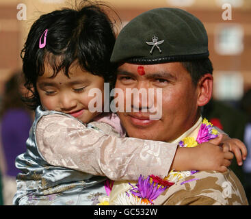 leutnant Korporal Ajay Tamang erhält eine willkommene Hausumarmung von seiner Tochter Sneha, 3, AS 25 Foxtrot Company - bestehend aus rund 100 Mitgliedern des 1. Und 2. Bataillons der Royal Gurkha Gewehre, die nach einer Dienstreise in Afghanistan in ihre Kaserne in Folkestone, Kent, zurückkehren. Stockfoto