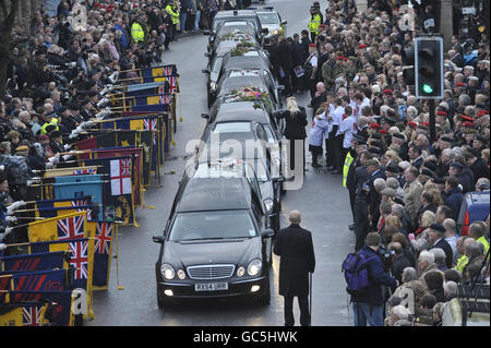 Die Trauernden legen Blumen auf den Cortege, der die Särge von Warrant Officer Class 1 trägt Darren Chant, 40, Sergeant Matthew Telford, 37, Guardsman Jimmy Major, 18, von der Grenadier Guards, Corporal Steven Boote, 22, Corporal Nicholas Webster-Smith, 24, von der Royal Military Police, Und Serjeant Phillip Scott, 30, ab dem 3. Bataillon passieren die Gewehre das Dorf Wootton Bassett in Wiltshire während ihrer heutigen Rückführung. Stockfoto