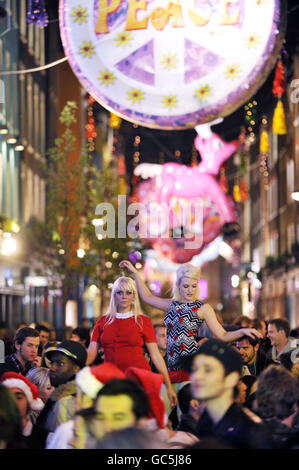 Zwei Tänzer beim Start der Carnaby Christmas, in der Carnaby Street, im Zentrum von London. Eine Open-Air-Disco lockte Hunderte von Tänzern zu der Veranstaltung, die den 50. Jahrestag der Straße feierte. Stockfoto