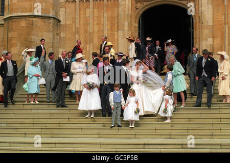 MITGLIEDER DER KÖNIGLICHEN FAMILIE, DIE HOCHZEITSFEIER UND ANDERE GÄSTE AUF DEN STUFEN DER ST. GEORGE'S-KAPELLE, WINDSOR, NACHDEM SIE AN DER HOCHZEIT VON LADY HELEN WINDSOR, TOCHTER DES HERZOGS UND DER HERZOGIN VON KENT MIT TIM TAYLOR TEILGENOMMEN HATTEN. Stockfoto