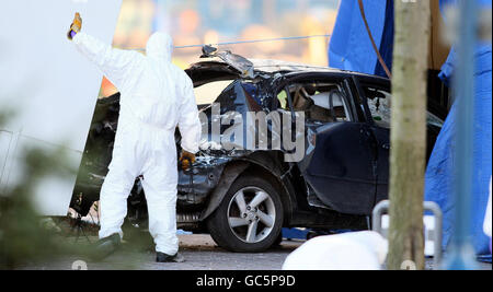 Forensische Polizeibeamte untersuchen das Gebiet, in dem eine Autobombe teilweise vor dem Hauptquartier des nordirischen Polizeipräsidums in Belfast explodierte. Stockfoto