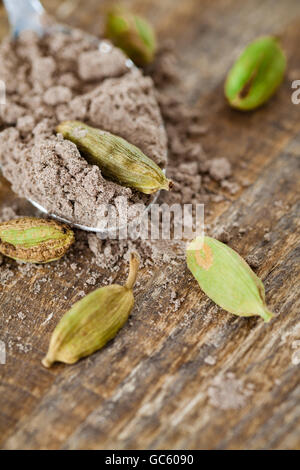 Kugel Boden Kardamom und Hülsen auf Holztisch. Stockfoto