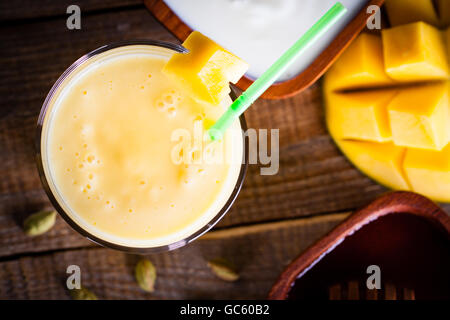 Overhead, machte Glas Milchshake Mango und Joghurt mit süßem Honig. Stockfoto