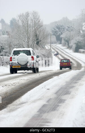 Winterwetter. Autos fahren nach starkem Schneefall in der Nähe der Stadt Bewdley in Worcestershire unbehandelte Straßen entlang. Stockfoto