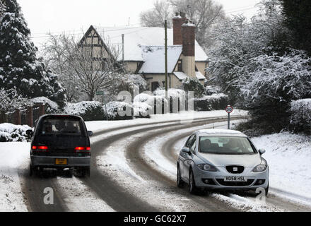 Der Verkehr führt durch das Dorf Littleworth in der Nähe von Worcester, wenn in Worcestershire starker Schnee fällt. Stockfoto