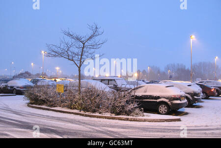 Winterwetter. Schneebedeckte Autos auf dem Parkplatz am Flughafen East Midlands. Stockfoto