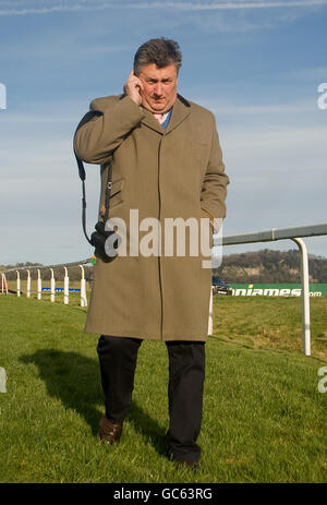 Trainer Paul Nicholls spricht auf seinem Mobiltelefon Überprüft den Zustand des Kurses vor dem Start von Die Rennen des Tages Stockfoto