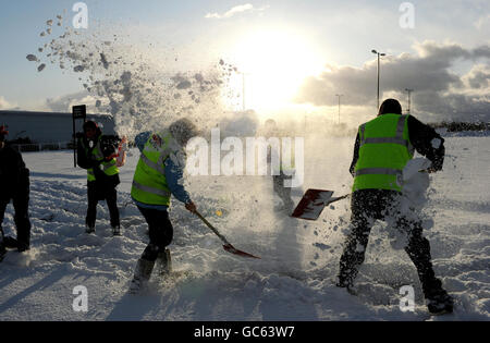 Mitarbeiter eines Kaufhauses in Shiremoor, Newcastle, nehmen sich Zeit, die Parkplätze zu räumen, um einen Schneekampf zu führen. Stockfoto