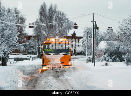 Ein Schneepflug räumt eine Straße in St. Boswells in den schottischen Grenzen, nach einer Nacht mit starkem Schneefall. Stockfoto