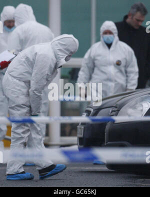 Auf dem Parkplatz des Supermarkts wurde ein Mann getötet. Polizei und forensische Beamte am Ort einer tödlichen Schießerei in der Nähe eines ASDA-Geschäfts in Glasgow. Stockfoto