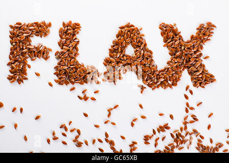 Wort-Flachs Leinsamen auf weißem Hintergrund gestapelt. Stockfoto