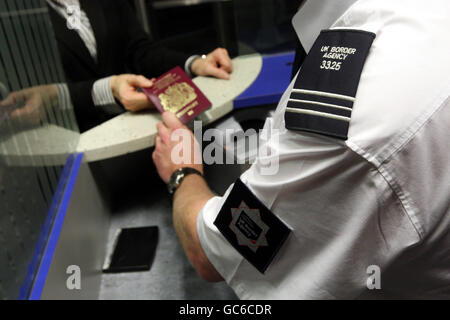 Gesichtserkennungs-Passsystem. Ein Mitarbeiter der britischen Grenzbehörde überprüft einen Reisepass im Nordterminal des Flughafens Gatwick, Sussex. Stockfoto