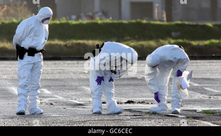 Forensische Polizeibeamte untersuchen das Gebiet, in dem eine Autobombe teilweise vor dem Hauptquartier des nordirischen Polizeipräsidums in Belfast explodierte. Stockfoto