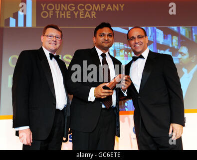 Der Unternehmer Theo Paphitis, rechts, und der Sponsor-Moderator Martin Allison, Dekan für Wirtschaft und Recht an der Leeds Metropolitan University, links, übergibt den Growing Business Award for Young Company of the Year an Mitesh Soma, Center, aus Leicester für Chemist Direct, im Marriott Grosvenor Square Hotel, London. Stockfoto
