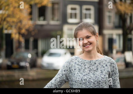 Junge Frau auf der Straße von Amsterdam, mit gelben Bäume im Herbst auf Hintergrund Stockfoto