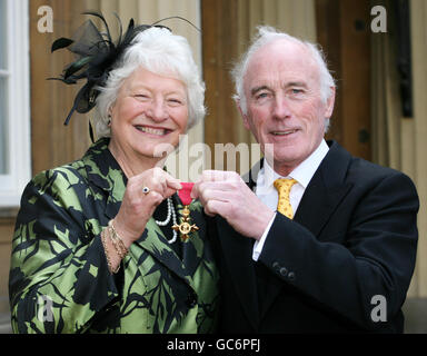 Bildhauer John Sherlock, begleitet von Dame Mary Peters, nachdem er seine Order of the British Empre Medaille (OBE) am Buckingham Palace vom Prince of Wales erhalten hatte. Stockfoto