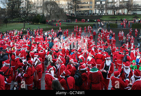 Santas nehmen am Great Scottish Santa Run in den West Princes Street Gardens, Edinburgh, Teil. Stockfoto