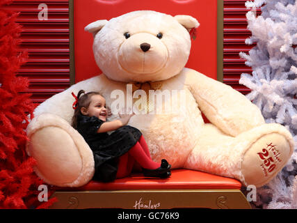 Demi Lindsay, 4, aus Bridgeton in Glasgow umarmt einen riesigen Teddybären bei der Eröffnung des weltberühmten Spielwarenhändlers Hamleys neuen 30,000 Quadratmeter großen Flagship-Stores im neuen Glasgows St. Enoch Center. Stockfoto