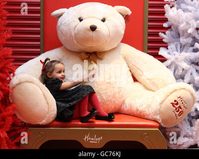 Demi Lindsay, 4, aus Bridgeton in Glasgow umarmt einen riesigen Teddybären bei der Eröffnung des weltberühmten Spielwarenhändlers Hamleys neuen 30,000 Quadratmeter großen Flagship-Stores im neuen Glasgows St. Enoch Center. Stockfoto